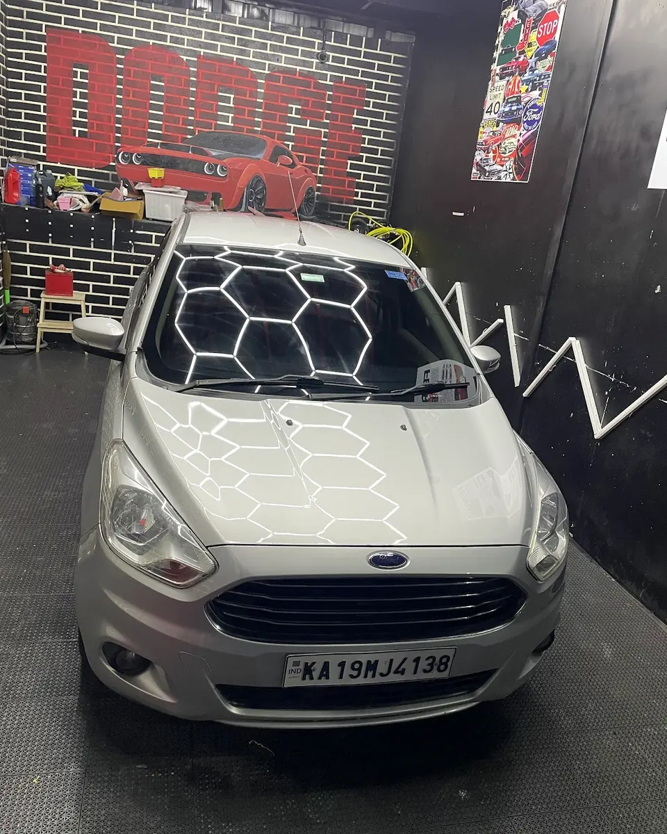 White hatchback under hexagonal ceiling lights