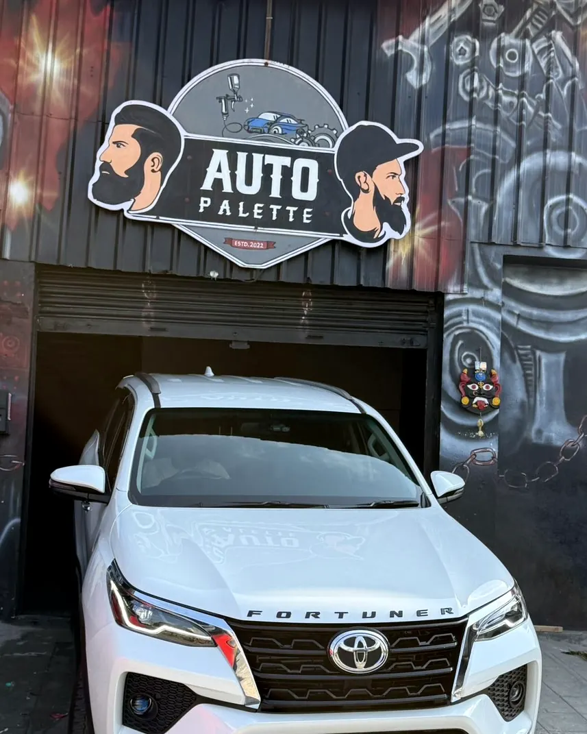 White Toyota Fortuner in front of the Auto Palette sign