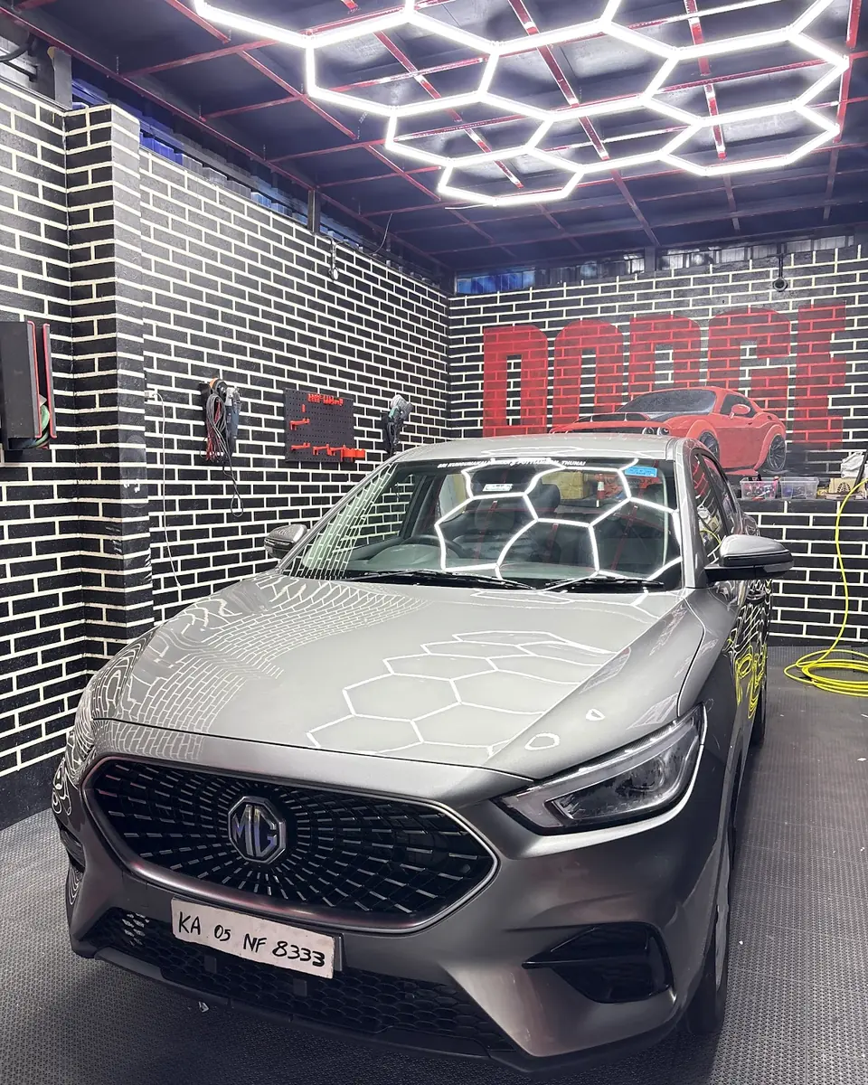 Silver sedan under hexagonal ceiling lights